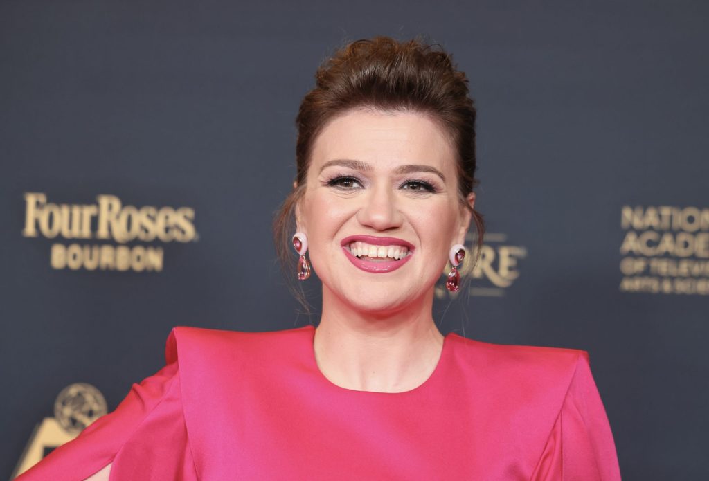Kelly Clarkson sonriendo en la alfombra roja de una gala de premios de televisión.