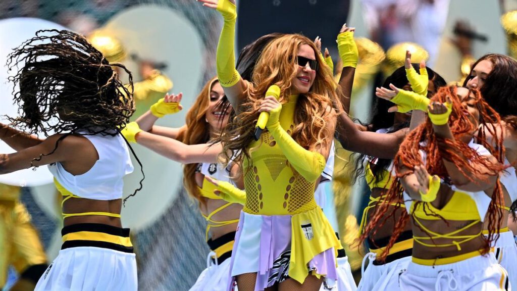 Shakira cantando en un escenario durante un evento deportivo