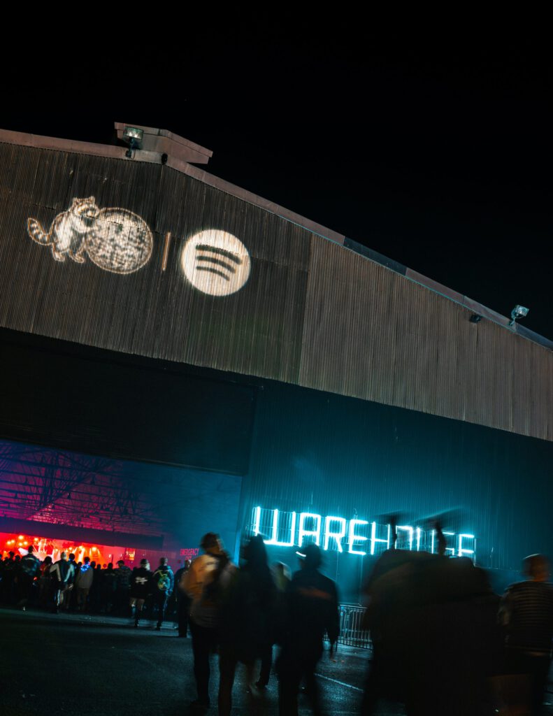 Escenario de un festival de música electrónica con público bailando